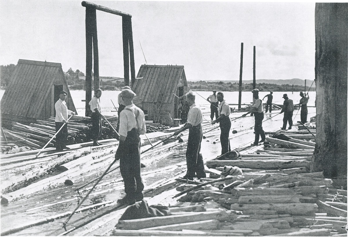 Historisk foto av personer som sorterer tømmerstokker ute på elva.
