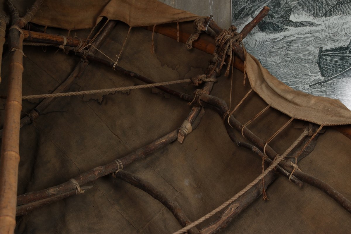 En båt laget av seilduk fra bunnen av et telt, som er spent over et rammeverk av bambusstenger og vidjegrener. Treverket holdes sammen av tau og remmer. Båten er konstruert av åtte langsgående og fem tverrgående  
sammenføyde vidjegrener. I tillegg holdes formen stiv av en bambusstav i bunnen, samt av hele eller kløyvde bambusstaver langsmed båtens øverste kant. To tverrgående tau er spent over midten av båten. Foran i båten ligger det en tverrgående bambusstav som trolig skulle fungere som sitteplass. Seilduken er bundet fast til rammeverket i teltpluggfestene langs båtens kant. Det er 26 telpluggfester på babord side og 25 på styrbord side. Akterenden er sannsynligvis sydd på etter at rammeverket var ferdig.
I båten ligger det to årer, samt et åreblad. Årebladene er laget av seilduk spent over y-formede vidjegrener. Årebladene er montert fast på bambusstaver med tauverk. Opprinnelig hørte det fire årer til båten.