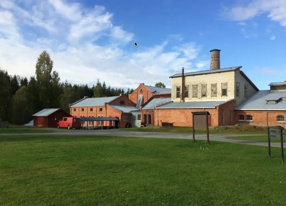 Klevfos cellulose og papirfabrikk er en stor fabrikk sett utenfra. Bygget er av rød murstein og har store vinduer.