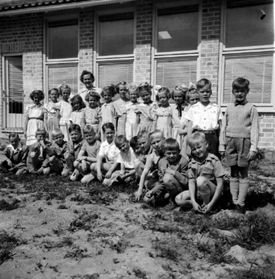 Rostaskolan, skolbarn med lärare fröken Olsson på skolgården.
Skolbyggnad i bakgrunden.
Från början hette skolan Rostaskolan, omkring 1955 bytte den namn till Hagaskolan och sen till Stjärnhusskolan. År 2019 är den förskola och har bytt namn igen.