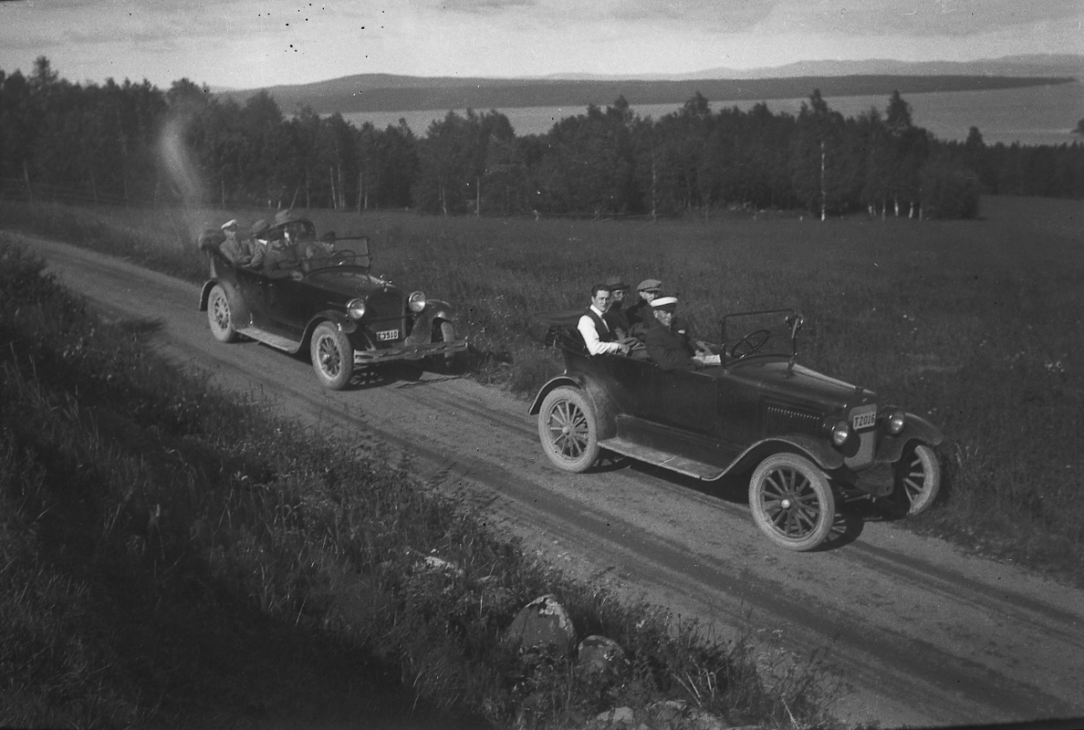 Två bilar. 
Den främre bilen är en Overland Four som ägdes av skräddaremästare A. J. Pettersson, Lindesberg. Den hade registreringsnummer T2016 och registrerades den 25:e april 1923 med honom som ägare. År 1930 finns bilen kvar i bilregistret, men ägs numera av Viktor Teodor Johansson, Bofors.
Den bakre bilen är en Dodge.