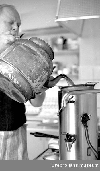 Folkets hus café. Kök, kokkaffe klart och fylls på från kaffepetter till termos, av Lasse.
Stina Bergdahl och Lasse Hjort har drivit cafét i 33 år och varit sambos lika länge.
Det har drivits café i lokalerna sedan huset var nytt 1928. Man har alltid serverat kokkaffe.
Stinas mor drev cafét före henne.