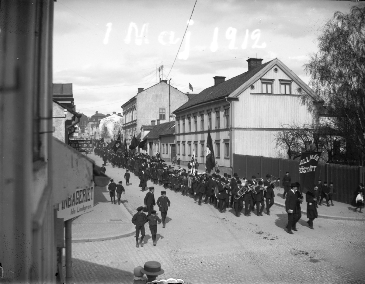 "1 maj 1912". Demonstrationståg Kyrkogatan, Enköping, sett från Sandgatan mot öster.