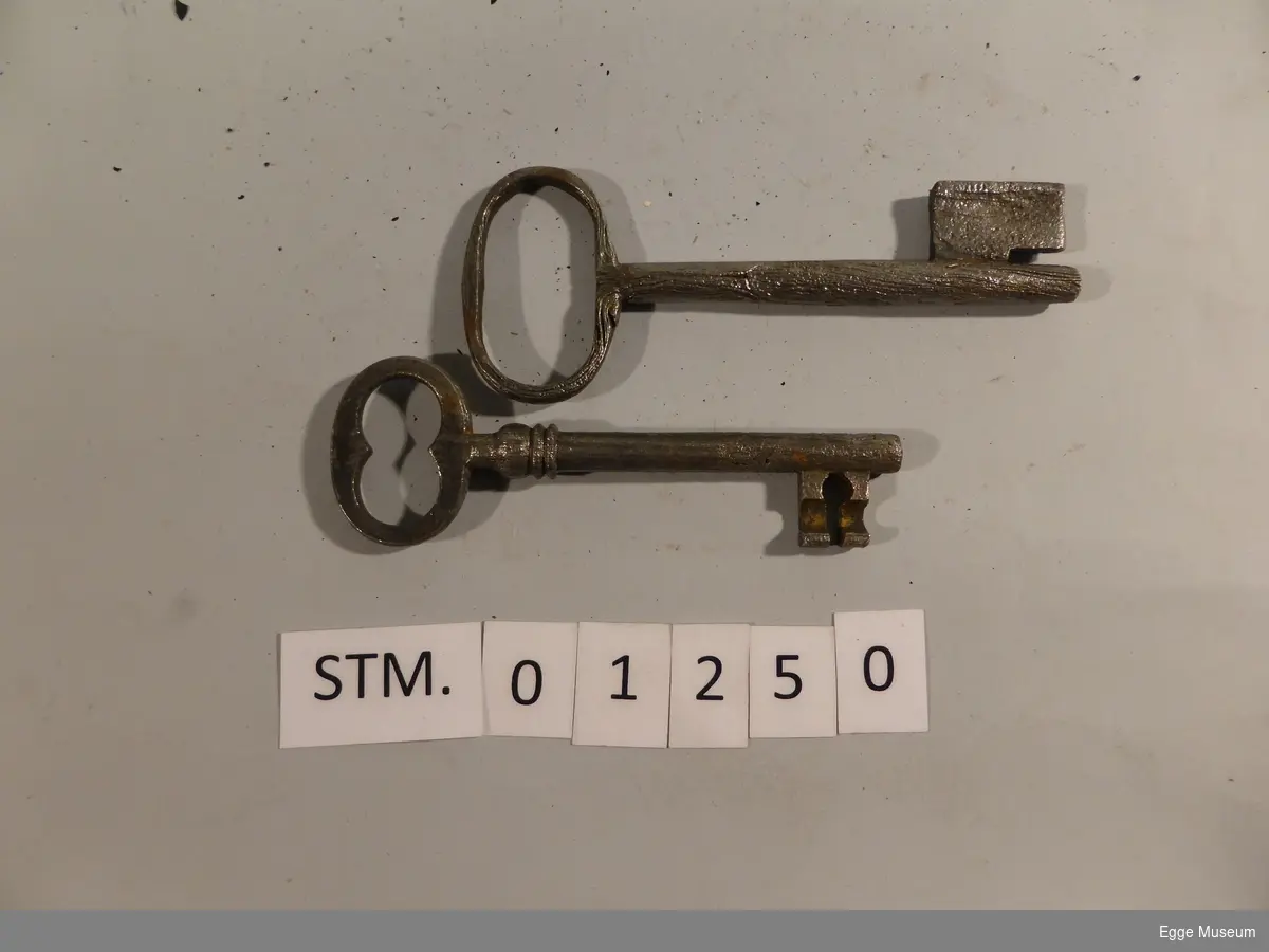 Form: Ett hakk i låssystemet på den ene, noe pæreformet hakk i låssystemet på den andre.
