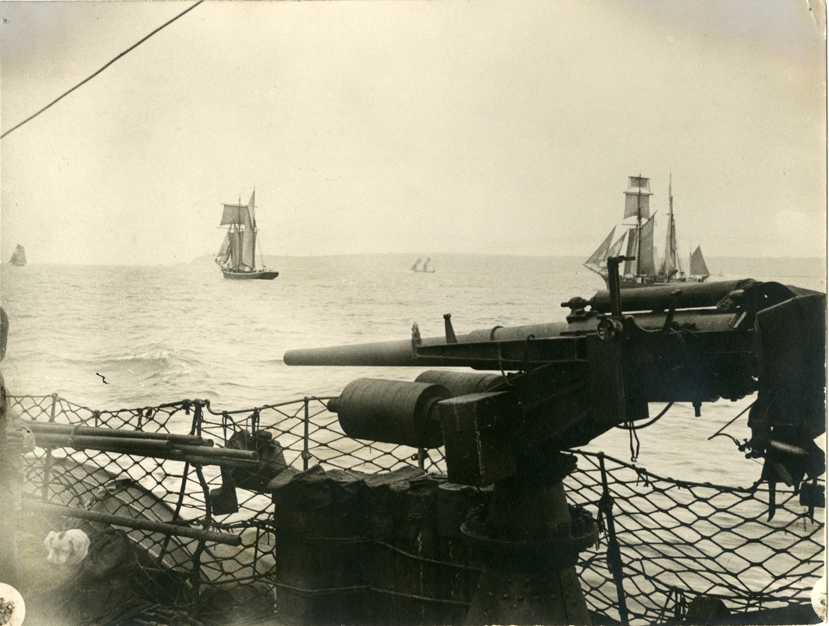 Kanon ombord i skip, seilskip i bakgrunnen
