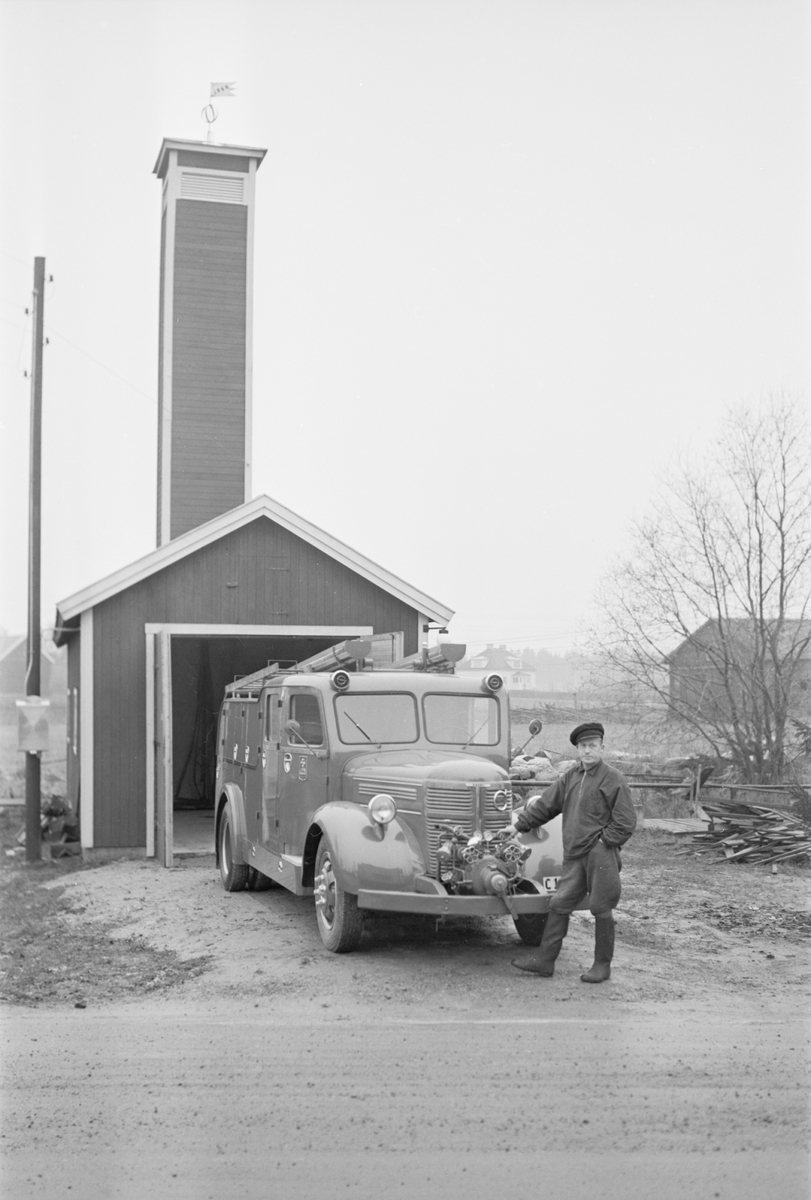 Man vid bil, sannolikt vid brandstationen i Hjälmunge, Uppland 1953