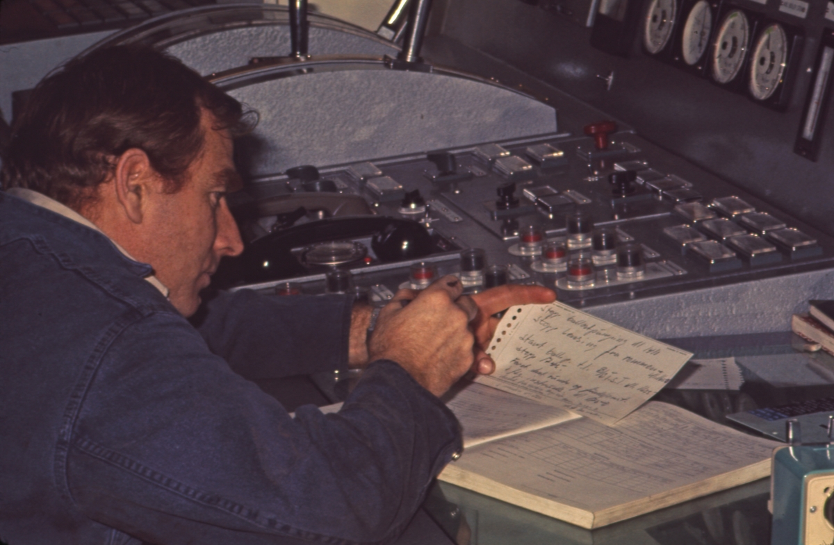 Kapteinen skriver i loggen ombord i M/S ‘Vikara’ (b.1973, Mitsubishi Heavy Industries Ltd., Kobe, Japan).