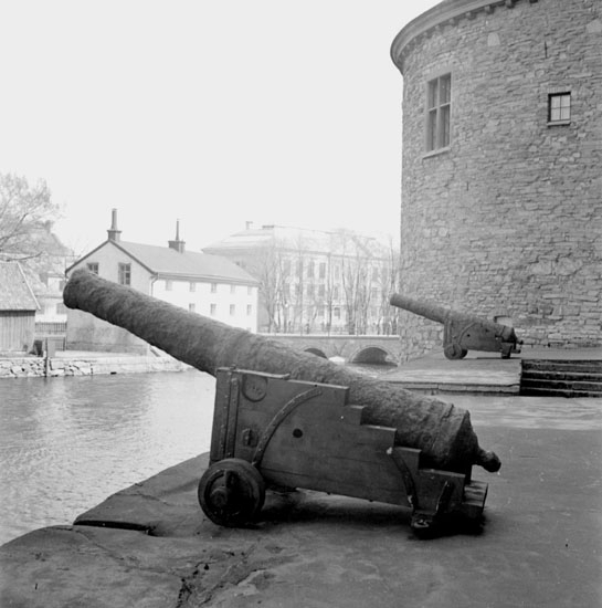 Örebro slott den 1 maj 1937. De båda kanonerna står nu uppställda på slottets norra terrass. I mars 1937 flyttades de hit från slottets södra sida, samtidigt som ett anläggningsarbete pågick på terrassen. I bakgrunden skymtar Arbetshuset, Kanslibron och Karolinska skolan.
