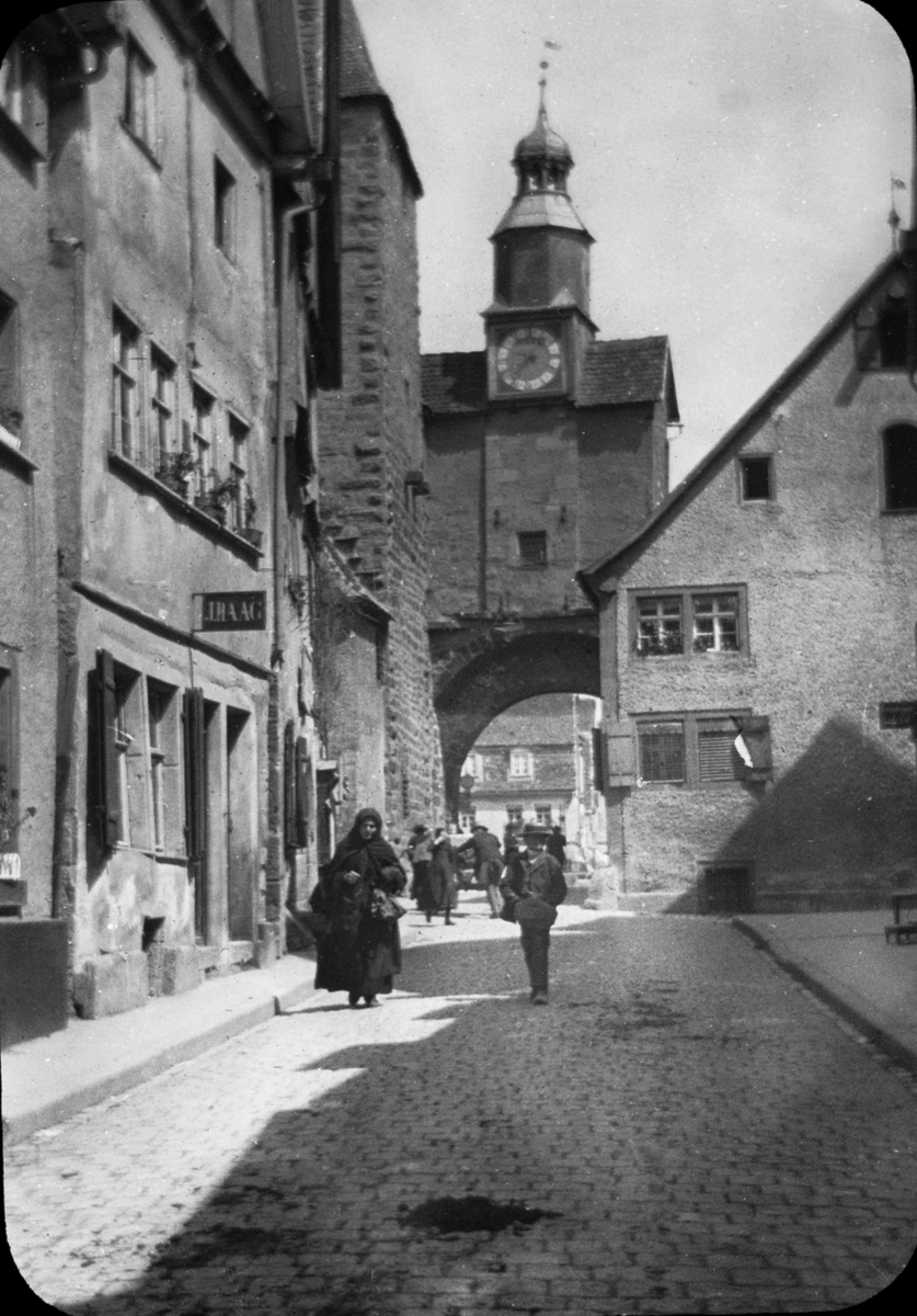 Skioptikonbild med motiv från Rothenburg.
Bilden har förvarats i kartong märkt: Rothenburg I. 1901. Text på bild: "Rothenburg a.d. Tauber Hafen Gasse. Markusturm".