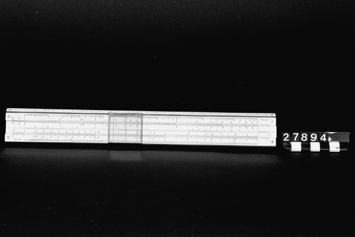 Logaritmisk räknesticka, "Diwa", typ Rietz, av plast, "Divinylen", på trä. Tabell med konstanter, på danska.