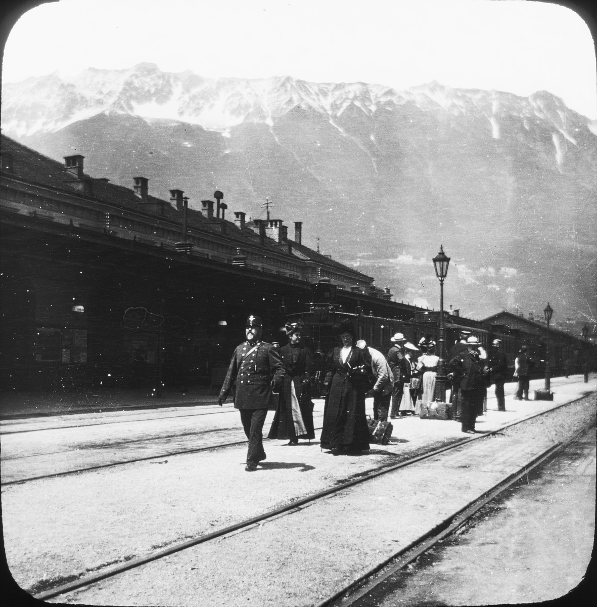 Skioptikonbild med motiv av resenärer längs Arlberg- banan mellan Innsbruck och Bludenz (Tyrolen).
Bilden har förvarats i kartong märkt: Resan 1906. Arlberg- banan 2. Konstanz 6. Text på bild: "Arlberg- banan".