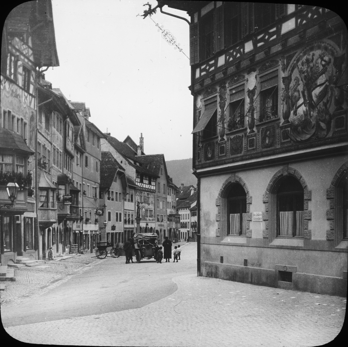 Skioptikonbild med motiv av automobil på Rathausplatz i Stein am Rhen.

Bilden har förvarats i kartong märkt: Resan 1908. Stein am Rhen 8. XIII