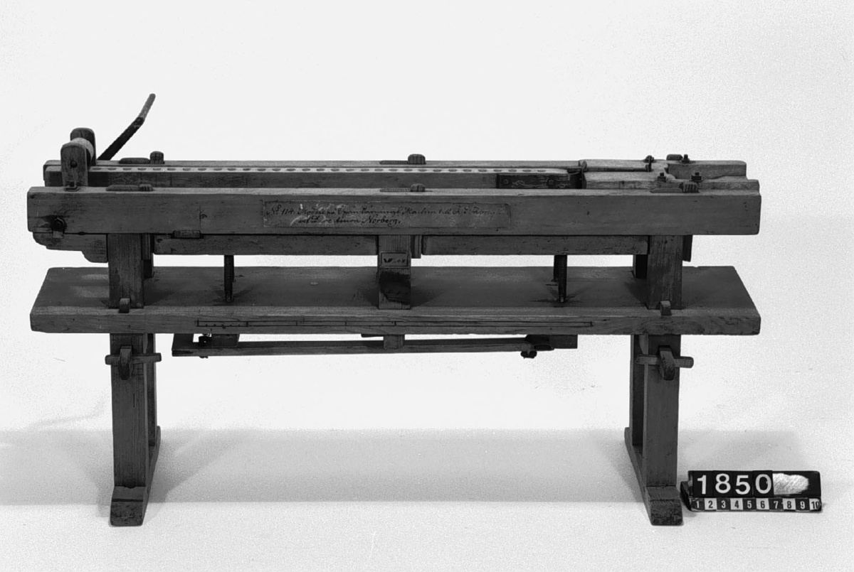 Modell av spånskärningsmaskin för askfabrik. Text på föremålet: "N:o 114. Modell på Spånskärnings Machin till Ask Fabriquer af Directeurn Norberg. Spånskärnings-maschin för ask-fabrik af Norberg. XIV.B.3. B-f-6".