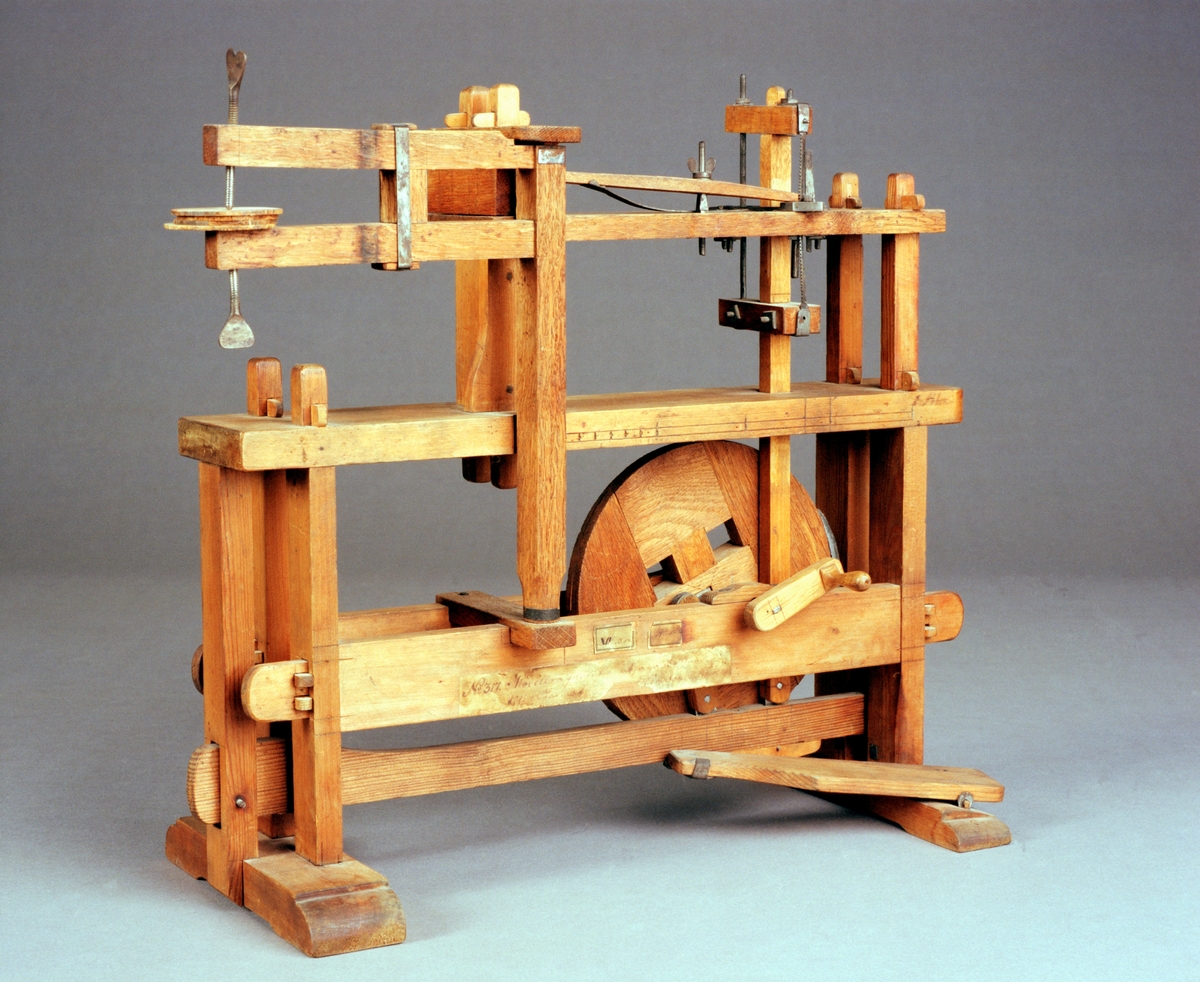 Modell av maskin för sågning av bottnar till askar. Text på föremålet: "N:o 317. Modell på Invention at såga Bottnar till Askar. Af fram .... Directeurn Norberg, XIV.B.18. B-d-(?) N:o 143."