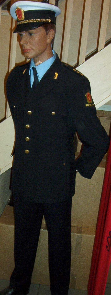 Til politiuniform tatt i bruk ved tusenårsjubileet 1997. Vist ved politibetjenten ved trapp nærmest "frigangshjemmet".