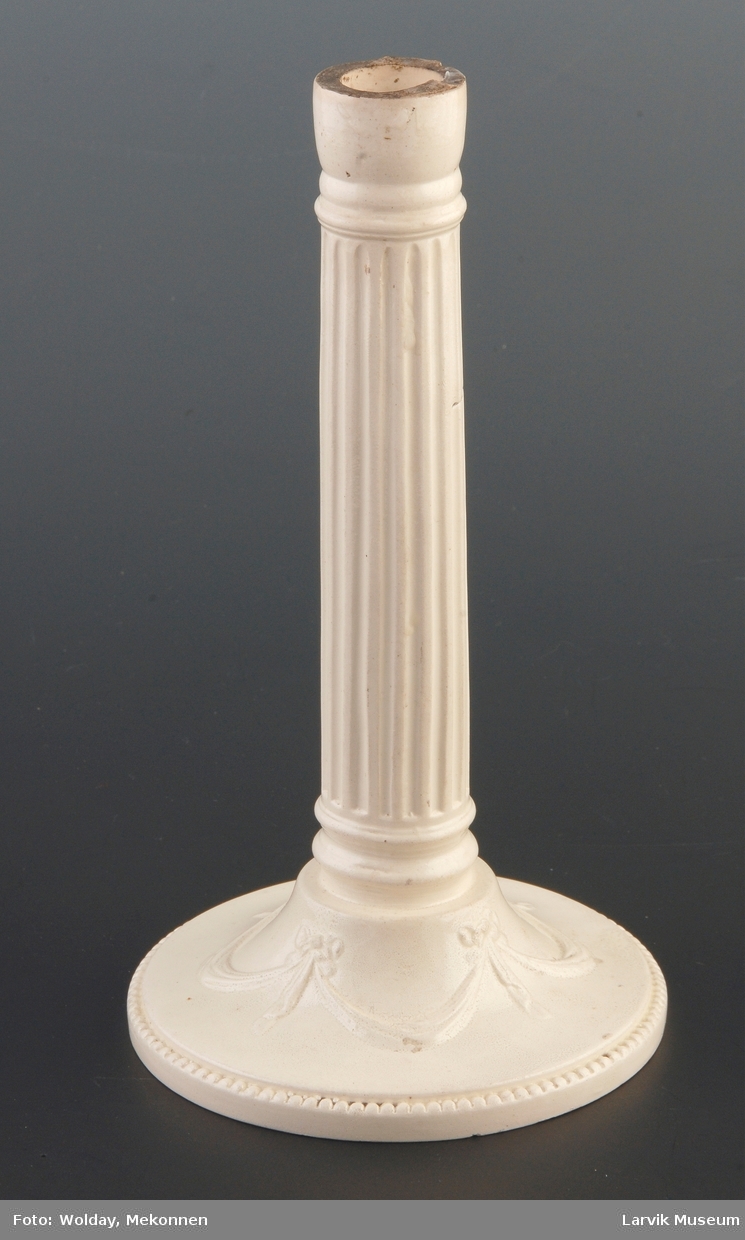 Form: foten perlestav og girlanderdekor. pipen formet som en jonisk søyle med base og kannelyrer