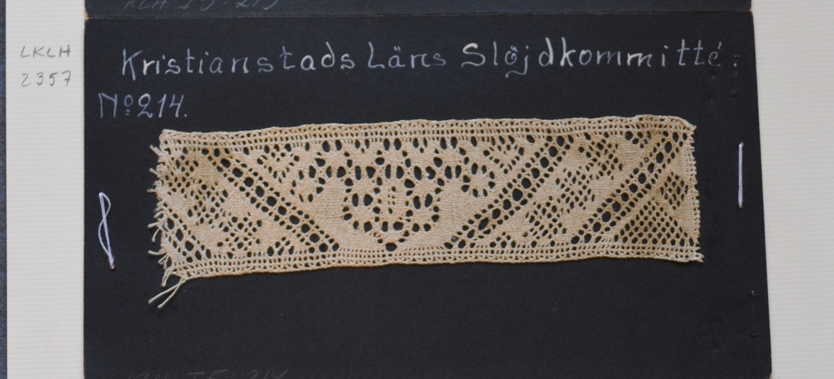 Kristianstads Läns Hemslöjdskommitté No 214.
Tulpan, sneda dubbla skack med småhålsstjärnor emellan.
Provet är monterat på svart kartong.