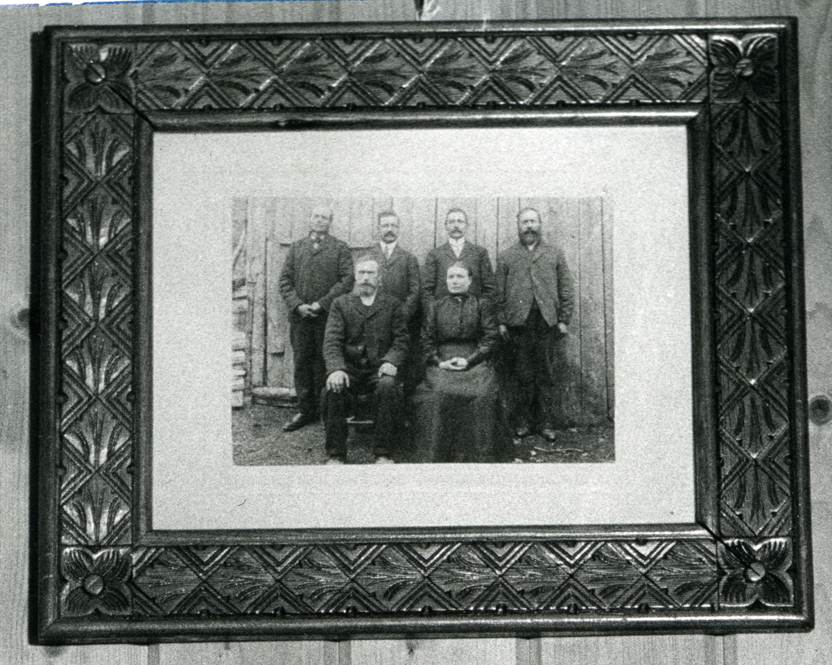 Avfotografert gruppebilde som viser fem menn og en kvinne. Alle er iført mørke klær.