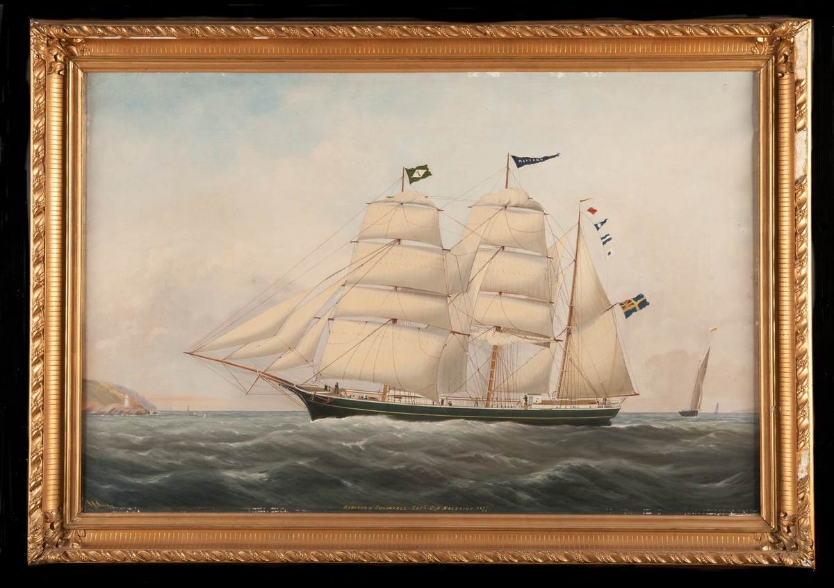 Tremastade barkskeppet MARY ANN av Sundsvall (1877), seglande för styrbords halsar, visande babords sida. Grönmålat skrov med gul list, vitmålad inombords. Unionsflagga på gaffeln. Neptuniordens flagga på fockmasten. T.v. kustparti, t.h, en jakt.
Stävornament.