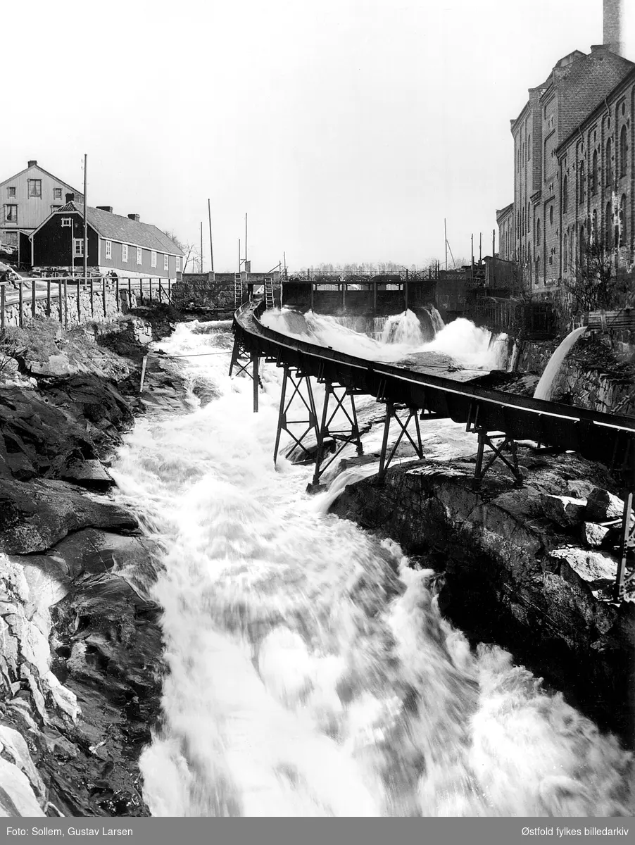 Fløtningsrenne ¨fra Svonedammen. Tatt fra Tista bru. Borgfoss til venstre og sliperiet til høyre. 
Jubileumsutstillingen 1914.