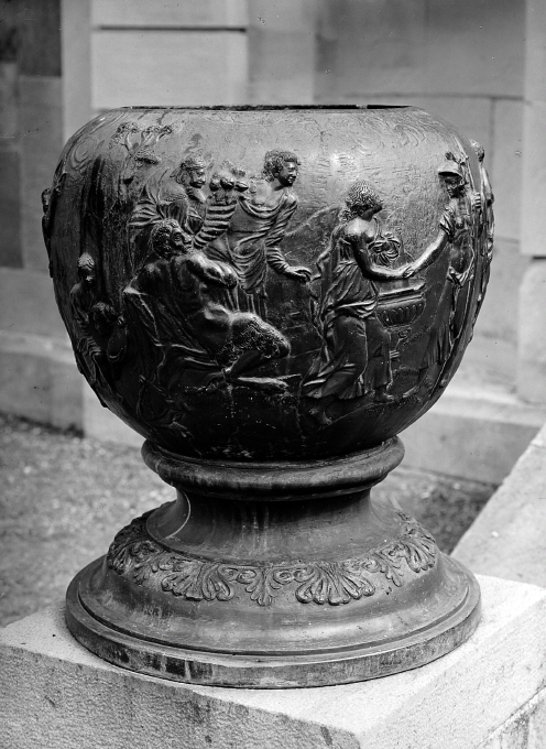 Urnan är prydd med reliefer framställande mytologisk scen.