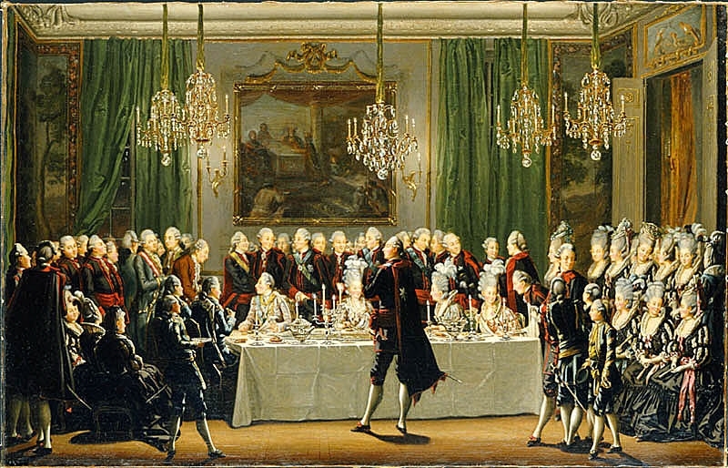 I mitten dukad taffel. Konung Gustaf III sitter längst till vänster med drottningen vid sin sida, till höger två damer. Konungen, framställd i profil till vänster, är iklädd dräkt av silvertyg, drottningen, framställd i fas höger, bär hög frisyr med plymer och urringgad klänning. Till höger om bordet sitta och stå hovdamer, bakom bordet stå hovmän samt utländska sändebud och till vänster står hovmän och sitter hovdamer, de flesta iklädda den svart-röda svenska dräkten. I förgrunden, vänd mot konungen, står en herre dirigerande uppassare, pager och kammartjänare. I bakgrunden väggparti, med infällda tavlor samt gröna sidengardiner, från taket hänga fem kristallkronor.