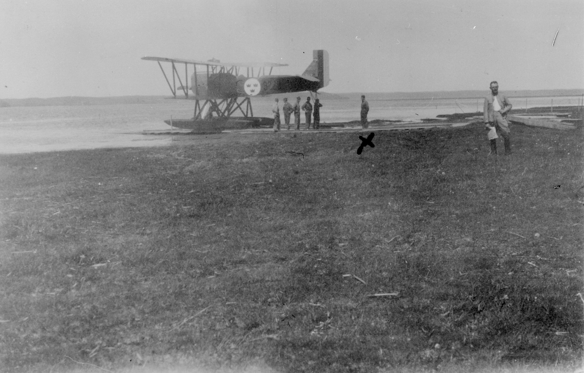 Sjöflygplan S 1 vid slipen på sjön Roxen. Militärer i rörelse kring flygplanet.