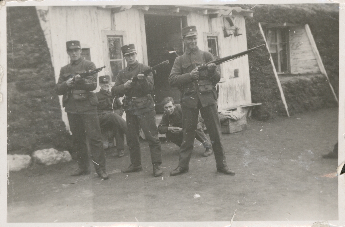 Fem soldater foran en gamme.