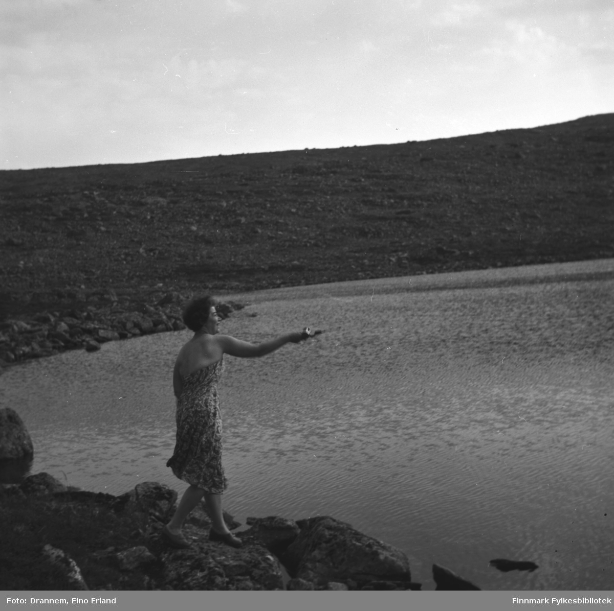 Jenny Drannem fotografert ved bredden av et fjellvann med fiskestang i handa.