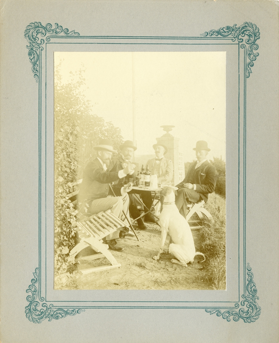 Albert Petersson og tre menn ved eit hagebord. 