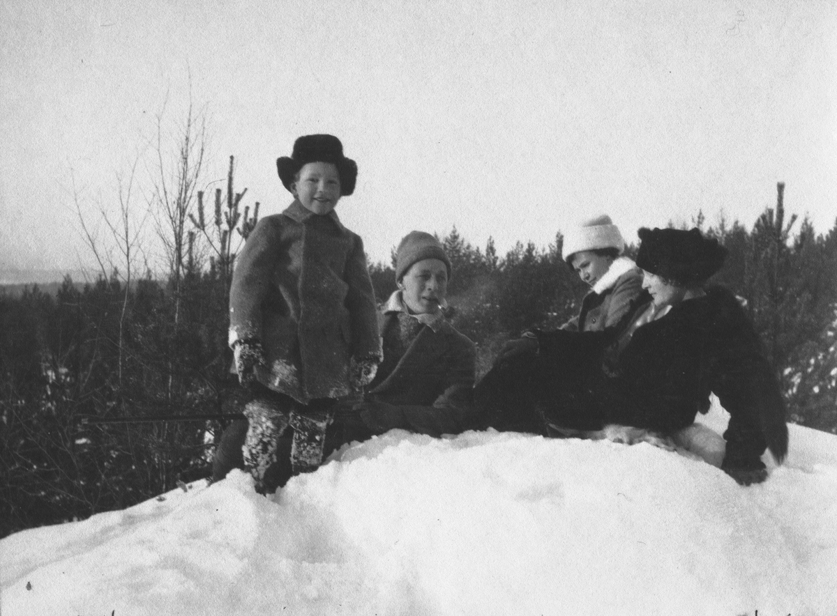 John och Ester Bauer sitter i en snödriva tillsammans med en pojke och en ung kvinna.