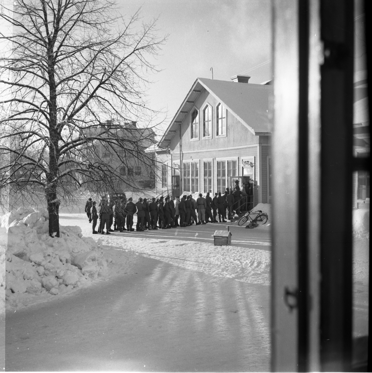 Värnpliktiga i en kö på en vinterdag på Norrlands dragonregemente K4, Umeå, 1955-1956.