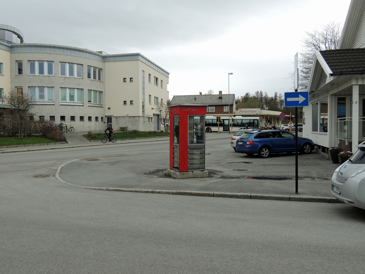 Denne telefonkiosken står ved politihuset i Bodø, og er en av de 100 vernede telefonkioskene i Norge. De røde telefonkioskene ble laget av hovedverkstedet til Telenor (Telegrafverket, Televerket). Målene er så å si uforandret. 
Vi har dessverre ikke hatt kapasitet til å gjøre grundige mål av hver enkelt kiosk som er vernet. 
Blant annet er vekten og høyden på døra endret fra tegningene til hovedverkstedet fra 1933.
Målene fra 1933 var:
Høyde 2500 mm + sokkel på ca 70 mm
Grunnflate 1000x1000 mm.
Vekt 850 kg.
Mange av oss har minner knyttet til den lille røde bygningen. Historien om telefonkiosken er på mange måter historien om oss.  Derfor ble 100 av de røde telefonkioskene rundt om i landet vernet i 1997. Dette er en av dem.