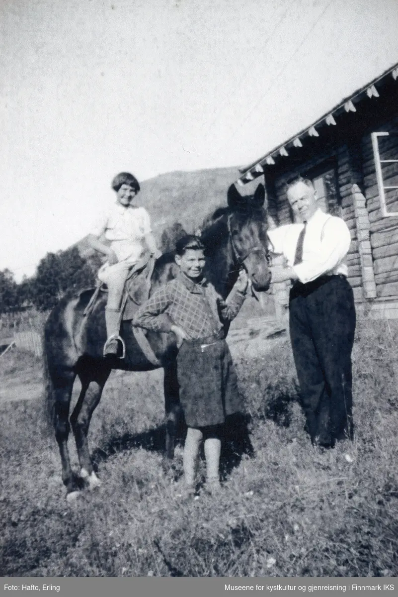 Vigdis, Gunnar-Helge og Erling Hafto med ridehesten "Frida" foran Rendulic-brakken i Tromsdalen, boligen til familien Hafto. 1945.