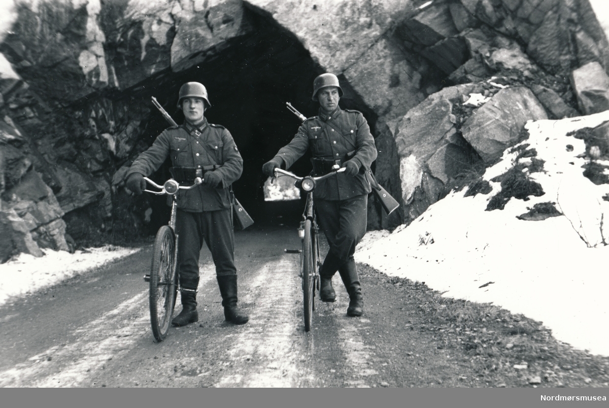 To soldater som står utenfor en tunnelåpning. Muligens tunnel ved Holbuvatnet