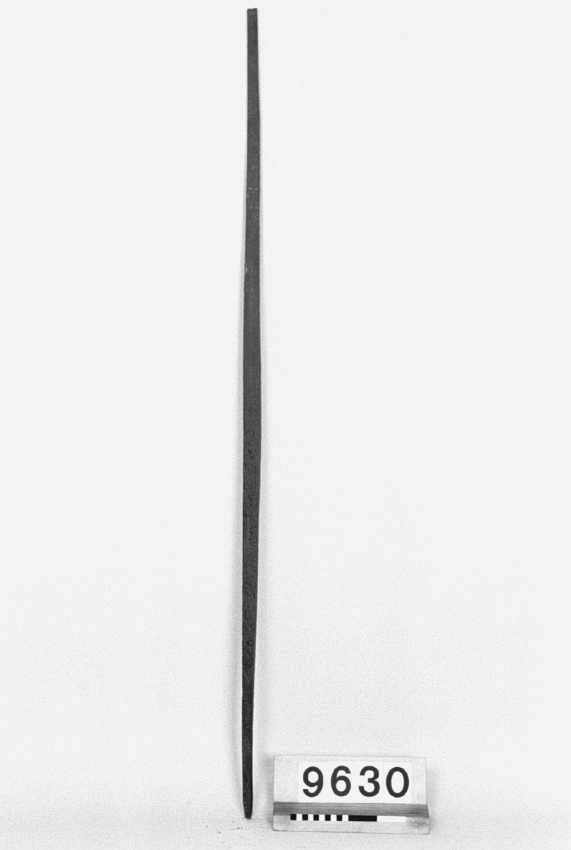 Smidd stång av brännstål, stämplad med klöverblad. Längd: 1420 mm, 26 x 28 mm vid mitten, 15 x 15 mm vid ändarna. Stången är formad som s.k. steyermarkstål.