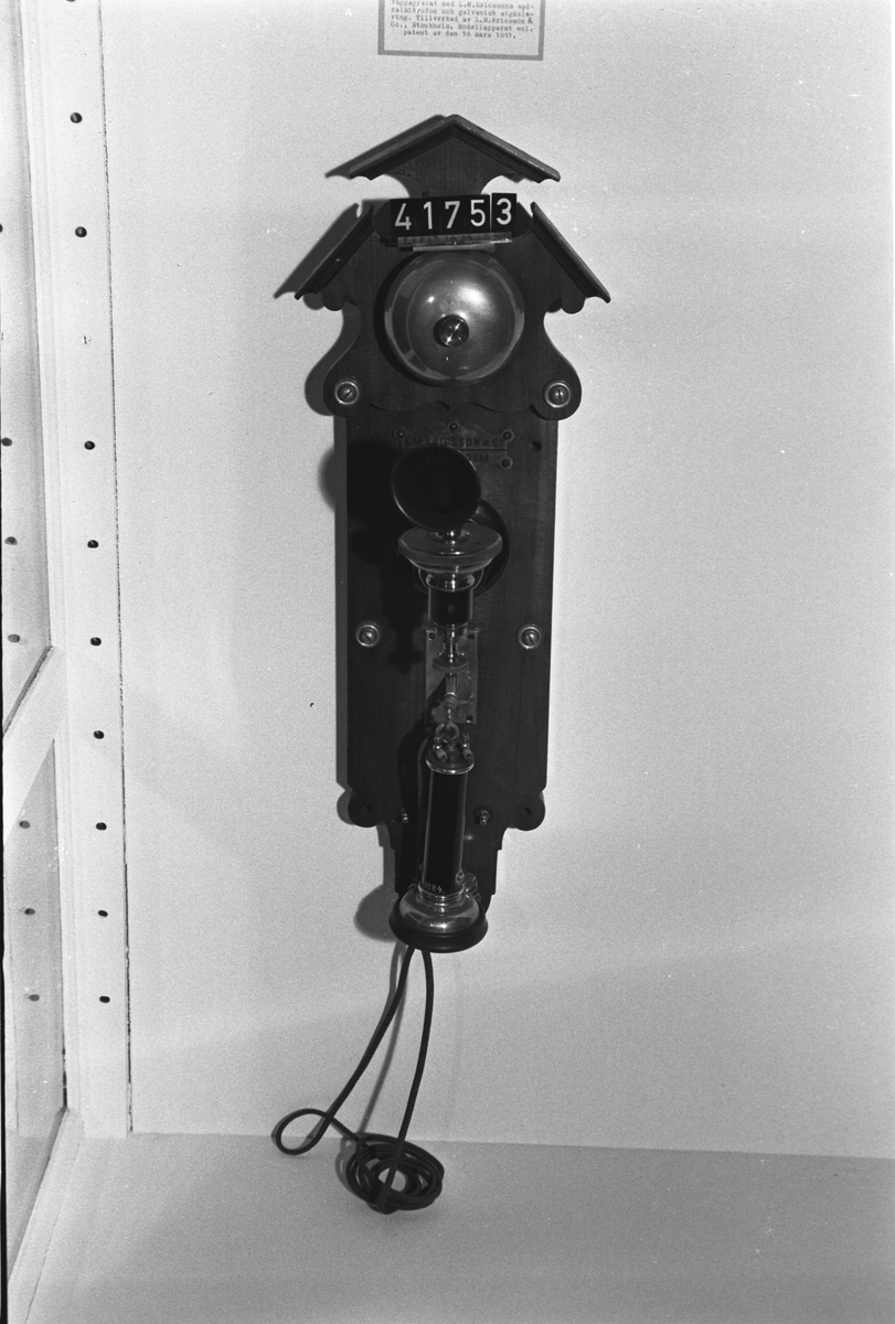 Telefonapparat, väggmodell med spiralmikrofon, för galvanisk signalering. För lokalbatteri. Modellapparat enl. patent 18/3 1881. Märkt: "L.M. Ericsson & Co Stockholm Patent".