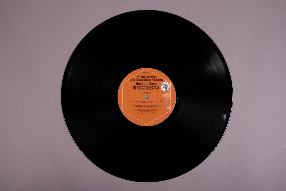 Plateomslag i form av en eske i oransje stoff, tre grammofonplater i svart vinyl som ligger i papirlommer, samt et hefte. I tillegg et klistremerke inne i  esken.