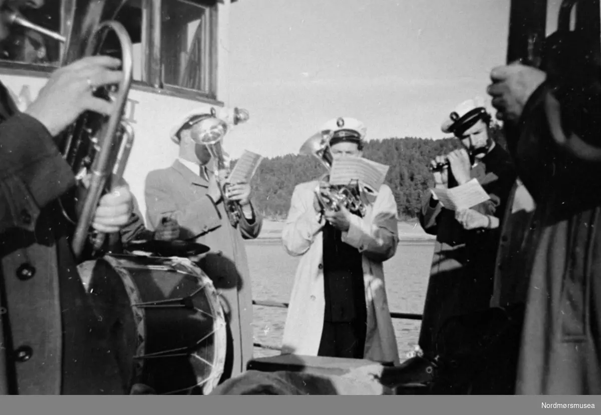 Frei Hornmusikk 17. mai 1953 ombord i motorbåten "Møst" spiller ved Aspøya.

Bilde fra fotoinnsamlinga i Frei 1978-79. Innsamla av Freielever på Nordlandet ungdomsskole og registrert av Margot Fiske. Fra Nordmøre Museum sin fotosamling.