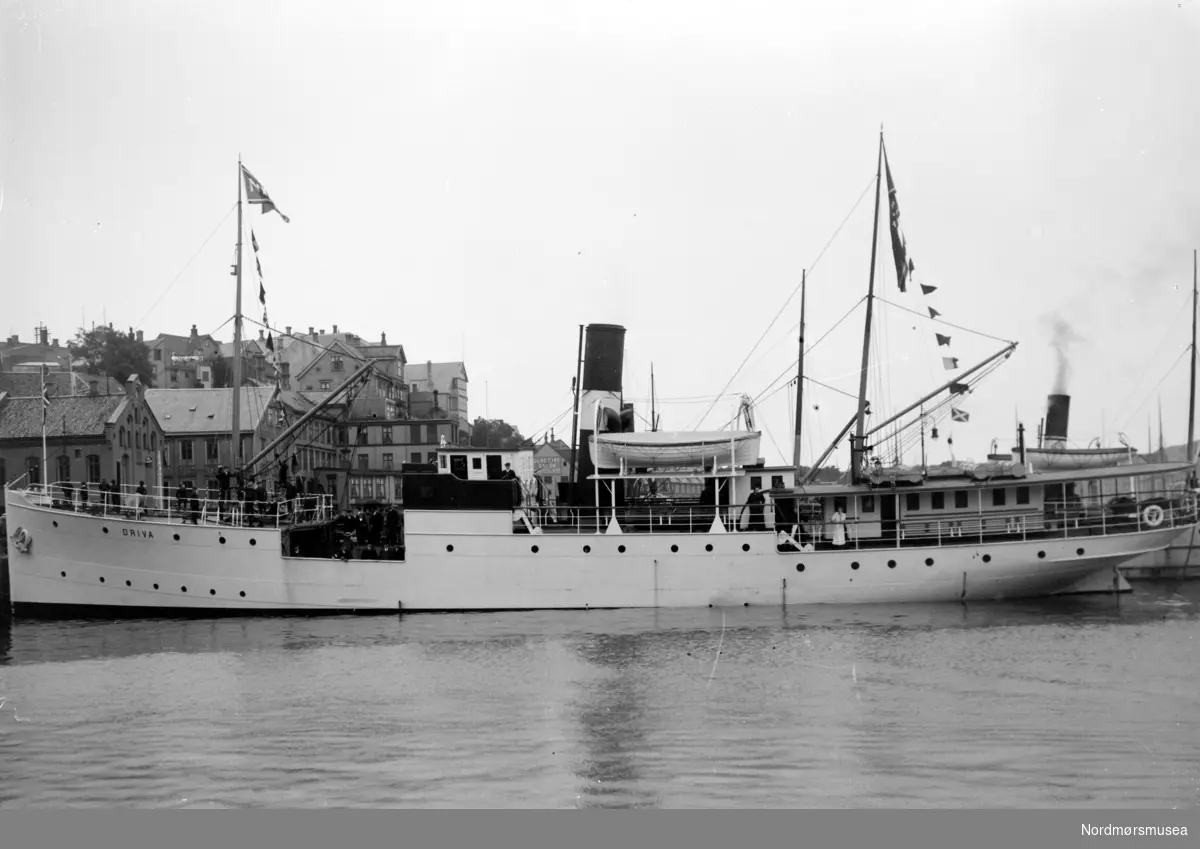 På bildet ser vi Dampskipet Driva til kai ved Piren/Kirkeallmenningen på Kirkelandet i Kristiansund. Fra Nordmøre Museum si samling.