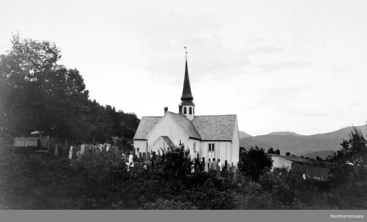 Motiv fra Halse kirke i Halsa kommune, med deler av gravstedet foran. Fotograf er Georg Sverdrup, og bildet er datert 1934. Fra Nordmøre Museums fotosamlinger. Reg: EFR
