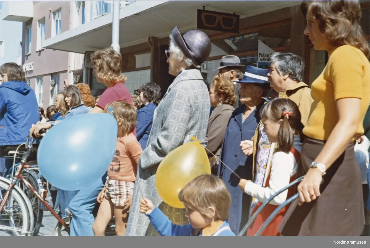 Foto fra Sverdrups bokhandel i jubileumsåret 1974, da bedriften feiret sitt 100 års jubileum. Her ser vi en gruppe mennesker oppstillt nær butikken i Nedre Enggate. Fra Nordmøre museums fotosamlinger. 