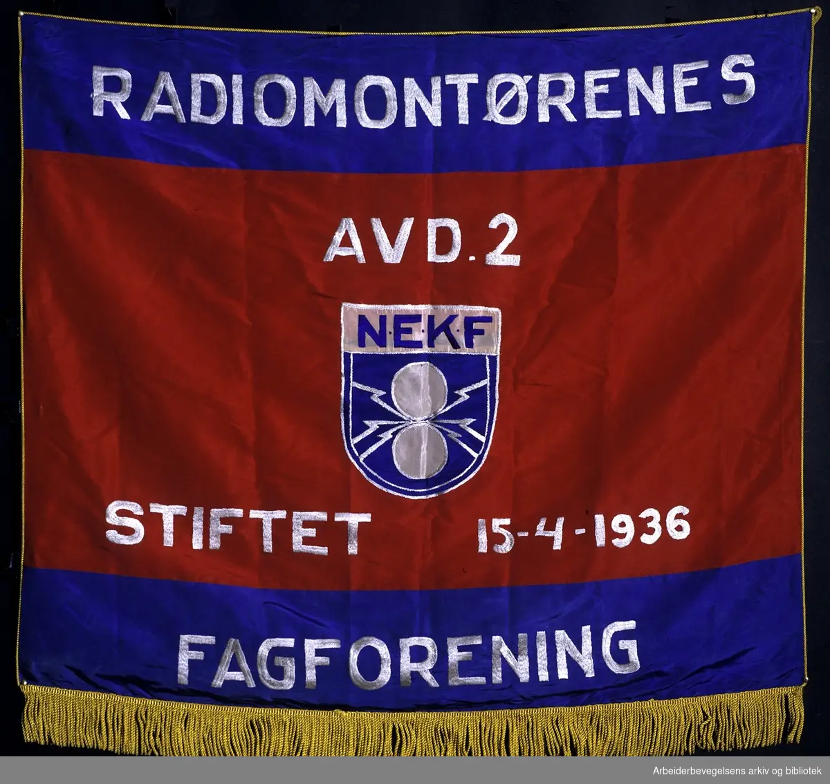 Radiomontørenes fagforening.Stiftet 15 april 1936..Forside..Fanetekst: Radiomontørenes Fagforening.Avd. 2. N.E.K.F..Stiftet 15 - 4 - 1936..Baksiden er lik.