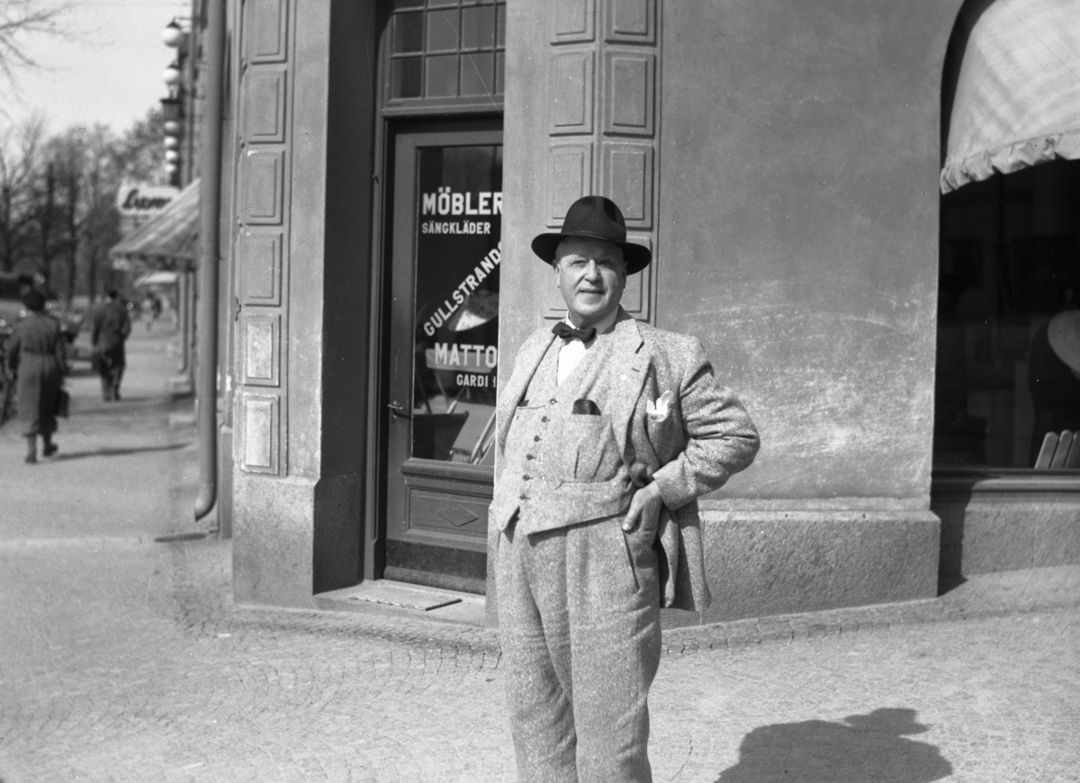 Bror Monsén, ägare till Gullstrands möbler, utanför butiken i hörnet av Östra Torggatan–Kungsgatan våren 1946.