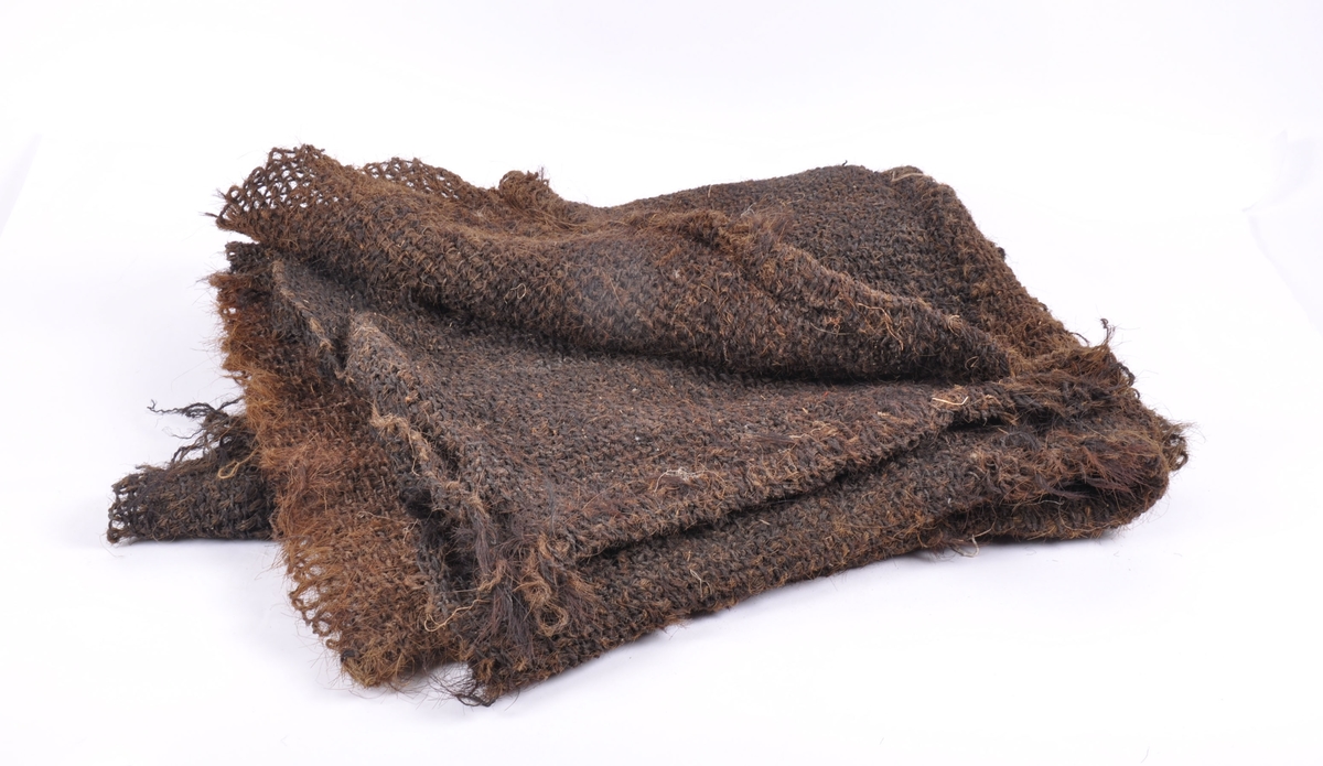 Grovt vevet teppe laget av grisebust, hestetagl og kuhalehår. 
To lange deler sydd sammen med en langsgående søm.