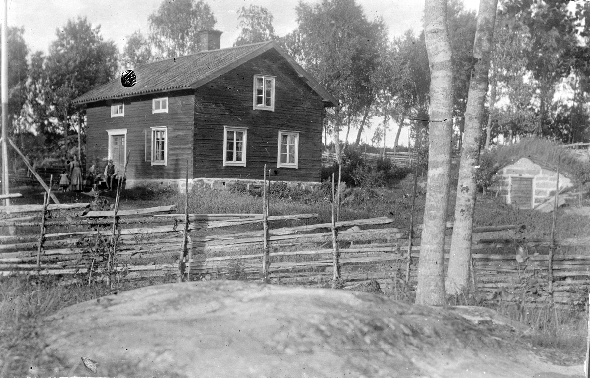 En man, en kvinna och ett barn framför ett hus. Fotograf Alfred Bergendahl. Givare H Bergendahl.