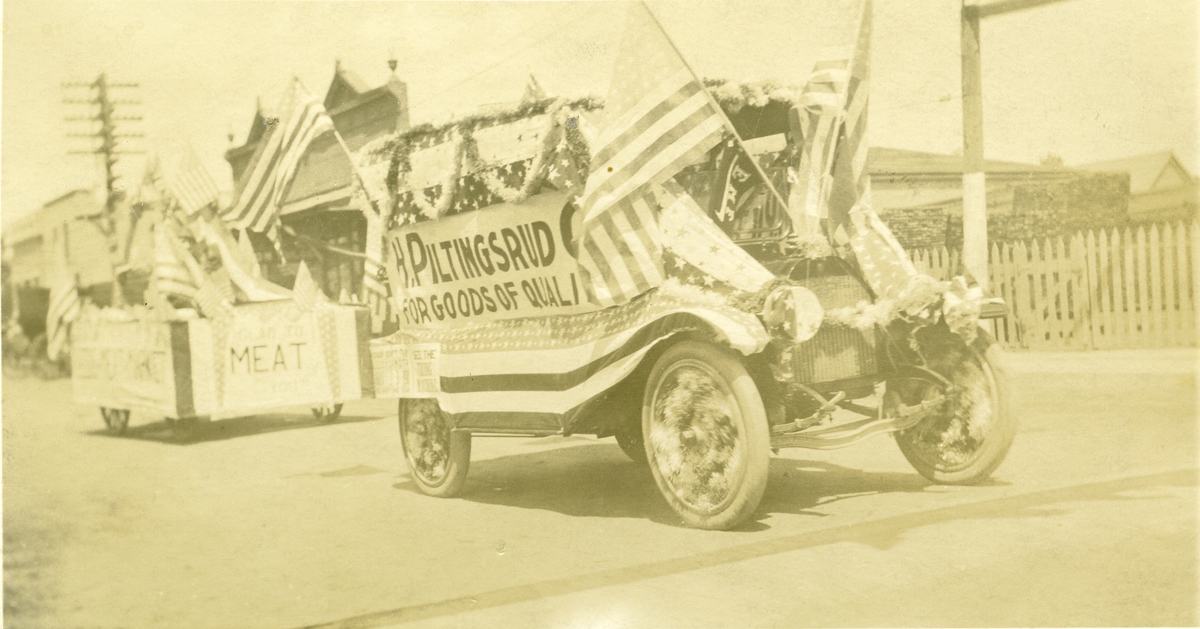 Fra en parade i Amerika. Bildet viser en bil med firmareklame for H. Piltingsrud.