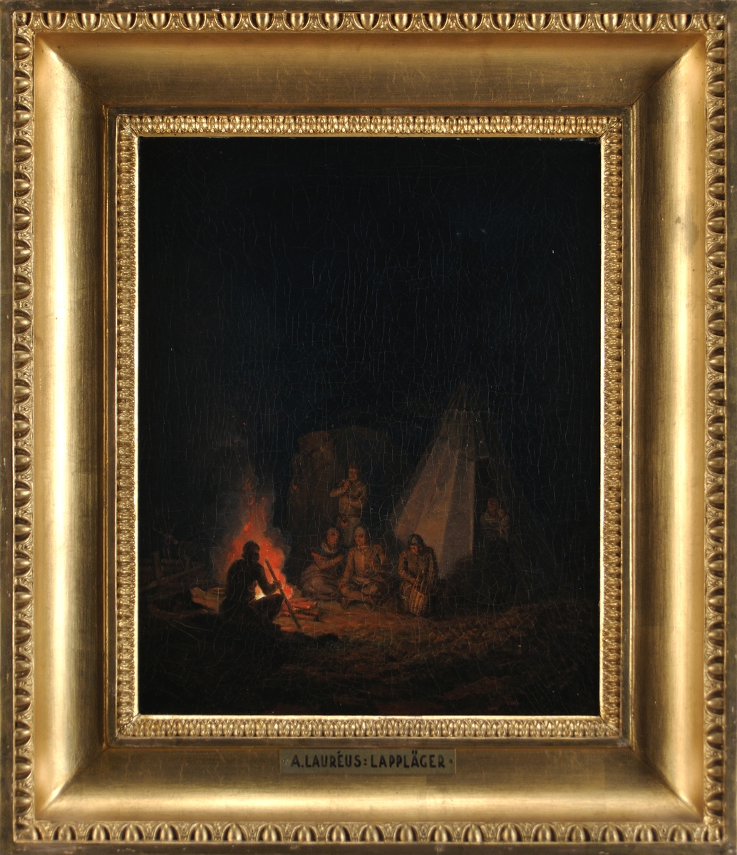 Samisk familj utanför kåta, ett par män röker, en arbetar med en korg. Till vänster flammande eld. Mörk bakgrund. Natt.