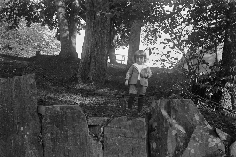 Valter Bergqvist, 1-2 år står intill en stenmur.
Fotot trol. taget i Braås herrgårdspark.