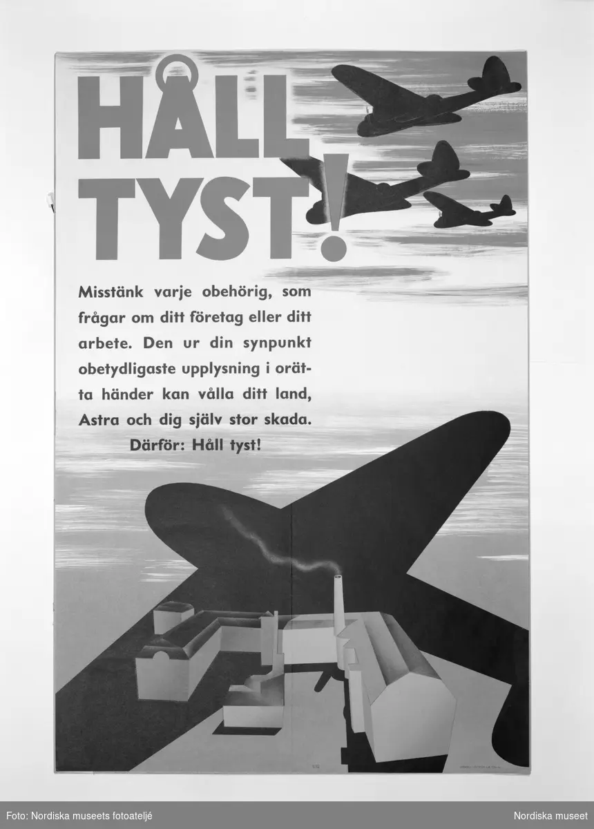 Affisch med uppmaningen "Håll tyst!" från avdelningen "Krig och kriser" i block 13 på Nordiska museets jubileumsutställning "Svenskens 100 år - känn dig själv". På affischen ses bombplan flyga ovanför bebyggelse med fabriker och rykande skorstenar.